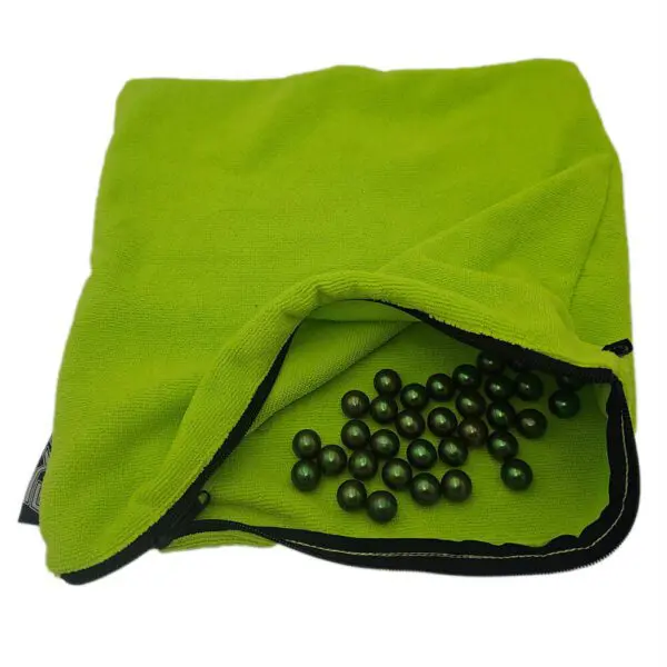 Green bag with scattered dark beads inside.